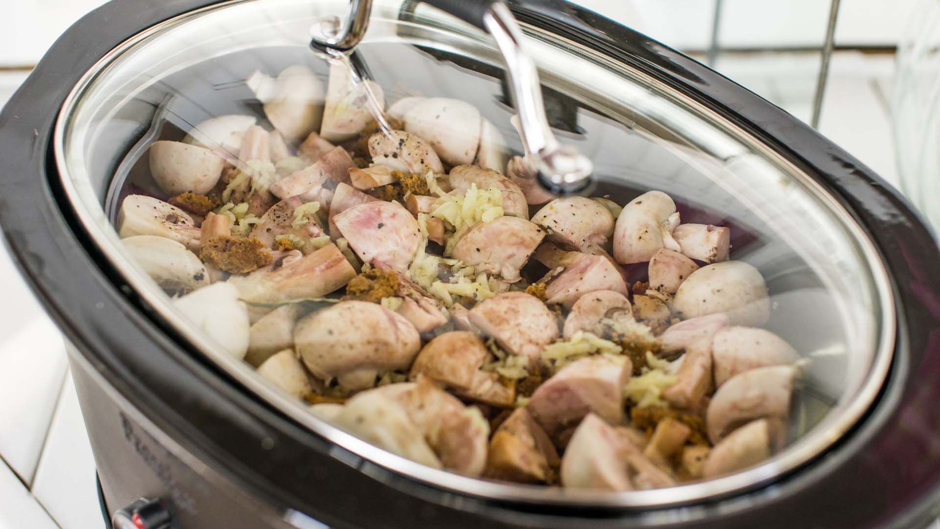 a beef stew being prepared in a slow cooker