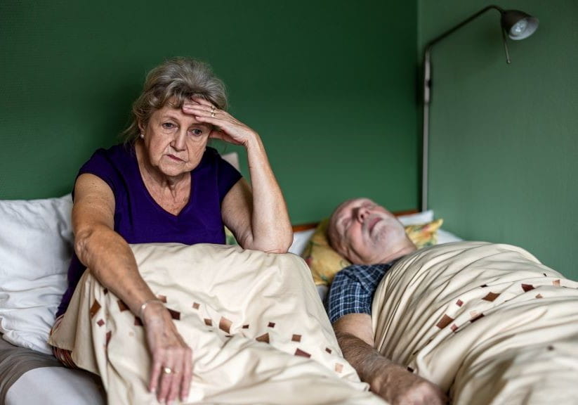 Senior woman can't sleep because her husband is snoring