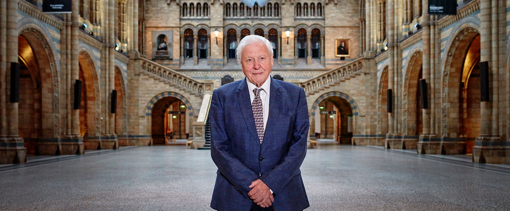 Sir David Attenborough standing in the Natural History Museum